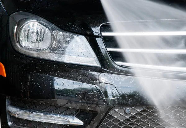 Lavado de autos. Coche moderno cubierto por el agua . — Foto de Stock