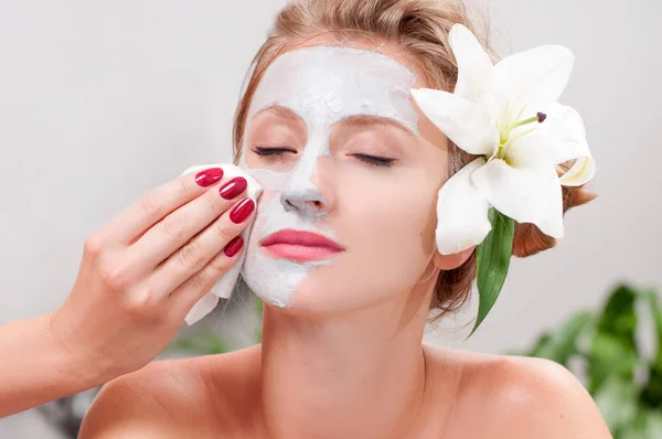 Spa salon. Beautiful woman with clay facial mask at beauty salon — Stock Photo, Image