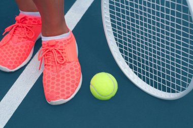 Kadın spor tenis top ve raket tenis kortunda ayakkabı ayaklarda