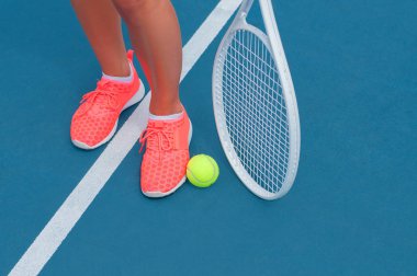Kadın spor tenis top ve raket tenis kortunda ayakkabı ayaklarda