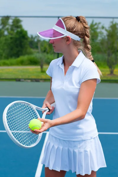 Tenista sosteniendo raqueta de tenis y pelota en la cancha de tenis — Foto de Stock