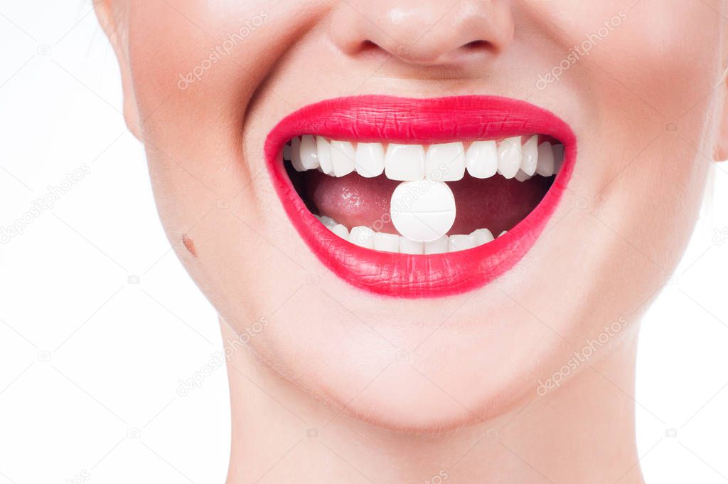 Female mouth with red lips and medicine pill 