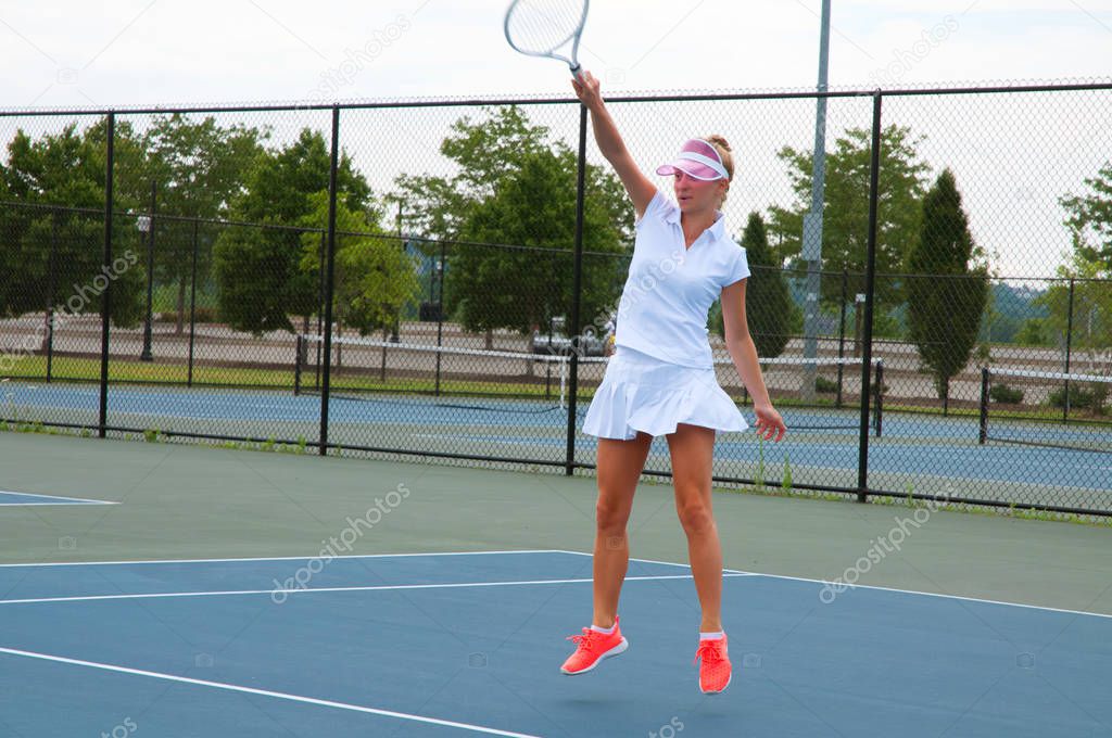 Young woman is playing tennis on the tennis court