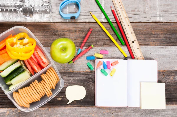 Okul malzemeleri ve ahşap arka plan üzerinde öğle yemeği. 
