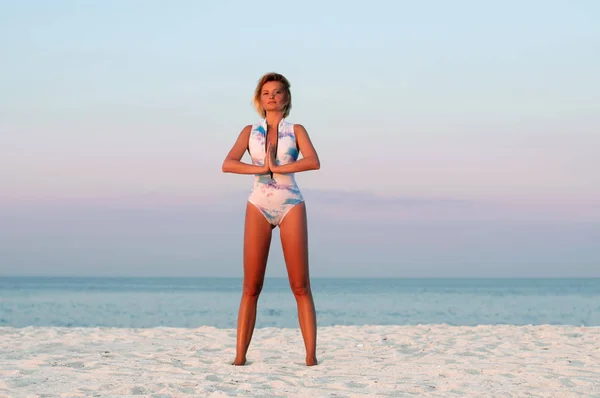 Красива жінка робить йогу на пляжі — стокове фото