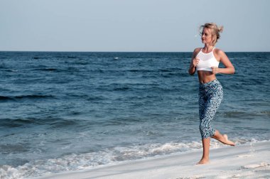  Sahilde çalıştıran atletik fitness kadın. Açık egzersiz.