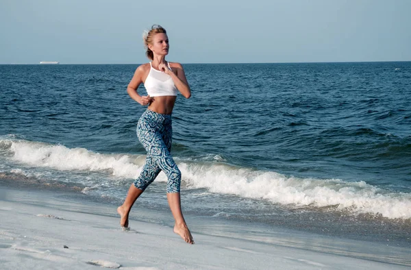 Спортивна фітнес-леді біжить на пляжі. Відкритий тренування . — стокове фото