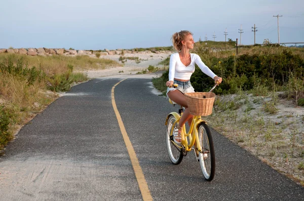 Беззаботная женщина с велосипедной ездой на пляже — стоковое фото