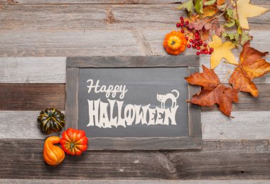 Kabaklar ve sonbahar yaprakları üzerinde ahşap arka plan. Cadılar Bayramı. Sonbahar konsepti