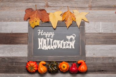 Kabaklar ve sonbahar yaprakları üzerinde ahşap arka plan. Cadılar Bayramı. Sonbahar konsepti