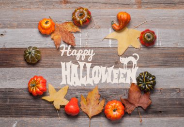 Kabaklar ve sonbahar yaprakları üzerinde ahşap arka plan. Cadılar Bayramı. Sonbahar konsepti