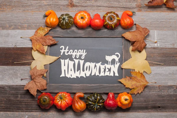 Kabaklar ve sonbahar yaprakları üzerinde ahşap arka plan. Cadılar Bayramı. Sonbahar konsepti