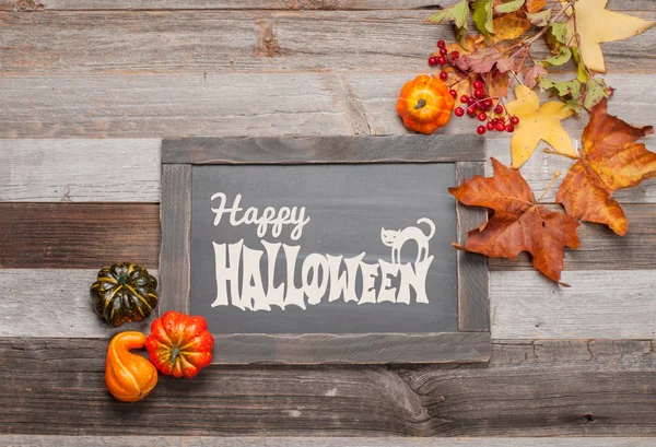 Kabaklar ve sonbahar yaprakları üzerinde ahşap arka plan. Cadılar Bayramı. Sonbahar konsepti