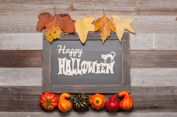 Kabaklar ve sonbahar yaprakları üzerinde ahşap arka plan. Cadılar Bayramı. Sonbahar konsepti