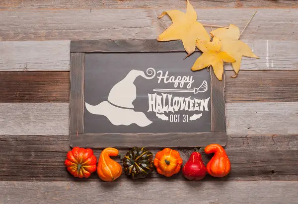 Kabaklar ve sonbahar yaprakları üzerinde ahşap arka plan. Cadılar Bayramı. Sonbahar konsepti