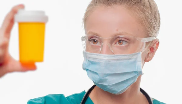 Médica, enfermeira segurando uma garrafa de pílulas em fundo branco . — Fotografia de Stock