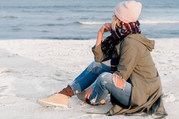 Yalnız kumsalda oturuyor ve mesafe içine arıyorum güzel kadın