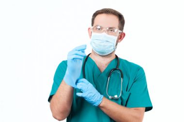 Erkek doktor stetoskop ve koruyucu maske ve eldiven.
