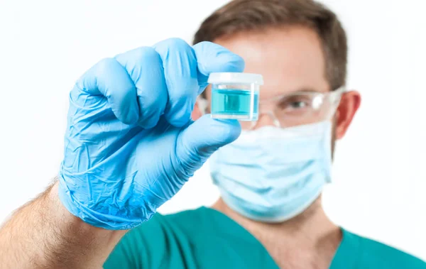 Médico em óculos de proteção segurando tubo de ensaio com reagente em laboratório — Fotografia de Stock