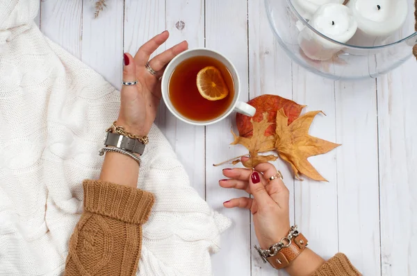 Vacanze d'autunno. Mani tenere la tazza di tè sul tavolo di legno . — Foto Stock