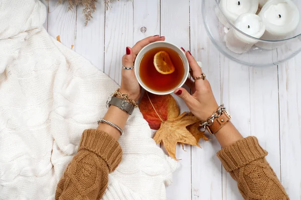 Vacanze d'autunno. Mani tenere la tazza di tè sul tavolo di legno . — Foto Stock