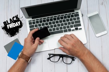 Tatil kavramı Online alışveriş. Kredi kartı tutan ve dizüstü bilgisayar kullanarak bir adam.