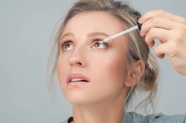 Güzel kadın gözleri göz damlası uygulayarak closeup