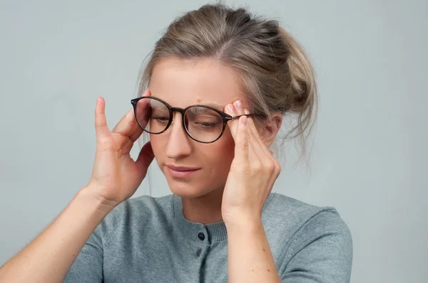 Mujer cansada en anteojos tiene dolor de cabeza —  Fotos de Stock