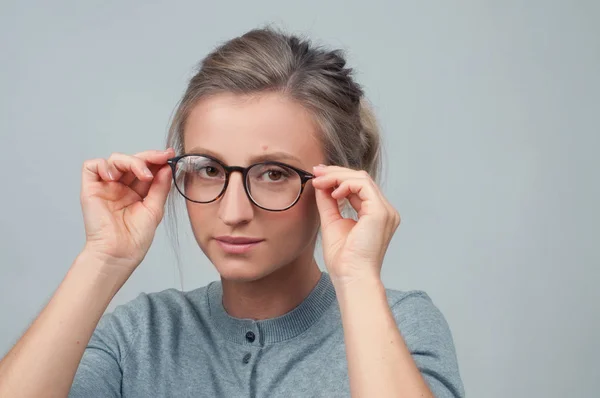 Молода жінка перевіряє нові окуляри — стокове фото