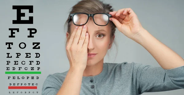 Woman in glasses. Eye test. Eyesight vision exam chart — Stock Photo, Image