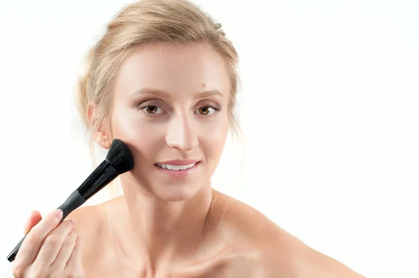 Mulher bonita aplicando cosméticos secos no rosto usando pincel de maquiagem . — Fotografia de Stock