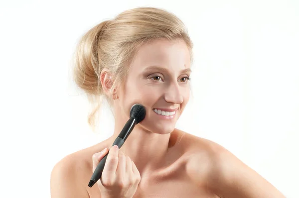Mulher bonita aplicando cosméticos secos no rosto usando pincel de maquiagem . — Fotografia de Stock