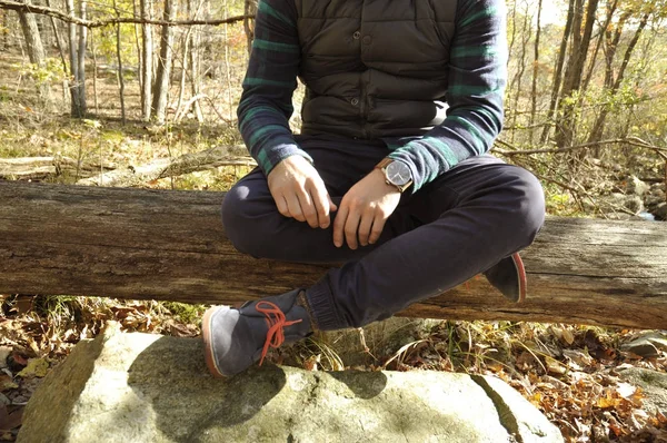 El hombre está sentado en el bosque de otoño en las montañas. Senderismo y viajes — Foto de Stock
