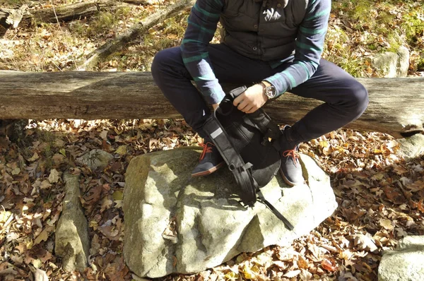 El hombre está sentado en el bosque de otoño en las montañas. Senderismo y viajes — Foto de Stock