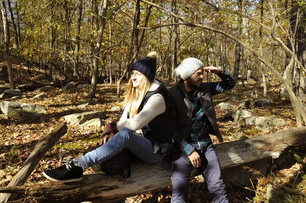 Pareja está sentada en el bosque de otoño en las montañas. Senderismo y viajes — Foto de Stock