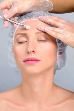 Kadın enjeksiyon alnından oluyor. Asansör anti-aging bakım ve yüz. Kozmetik tedavi ve plastik cerrahi