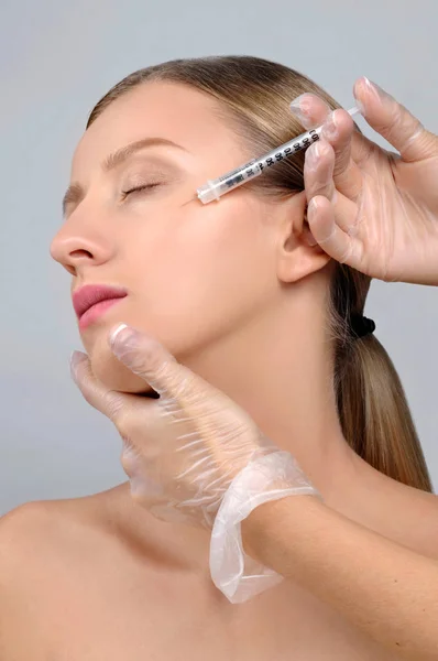 La mujer recibe la inyección de botox. Tratamiento antienvejecimiento y cara — Foto de Stock