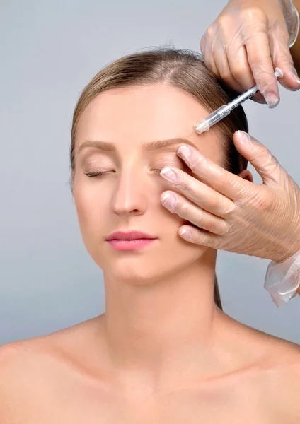 La mujer recibe la inyección de botox. Tratamiento antienvejecimiento y cara — Foto de Stock