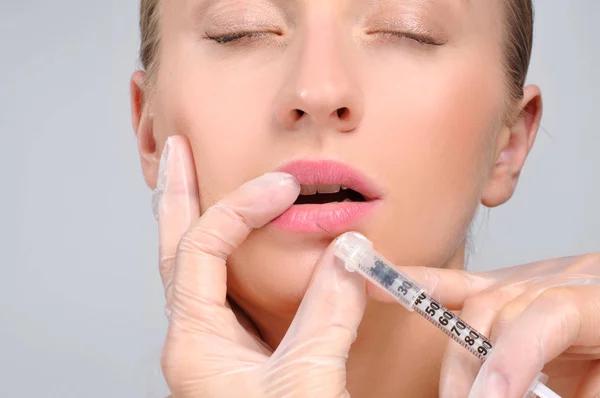 Hermosa chica recibiendo inyección de relleno en los labios. Botox. Cosmet. —  Fotos de Stock