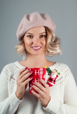 Noel ve yeni yıl. Kadın sıcak şapkalı bir fincan kahve tutuyor. 