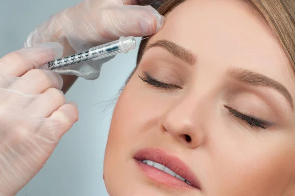 A nő egyre injekció szemöldök felett. Anti-aging kezelés és az arc lift. Kozmetikai kezelés és plasztikai sebészet — Stock Fotó