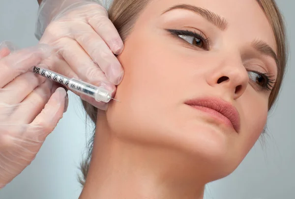 A nő arcán egyre töltőanyag injekciót. Anti-aging kezelés és az arc lift. Kozmetikai kezelés és plasztikai sebészet — Stock Fotó