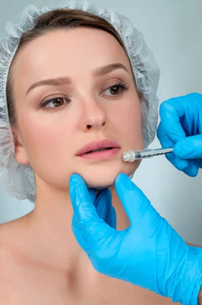 Hermosa chica recibiendo inyección de relleno en los labios. Surge plástico — Foto de Stock