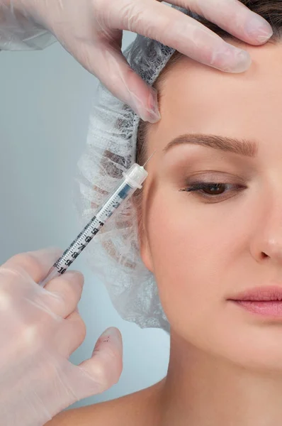 La donna viene iniettata sopra il sopracciglio. Trattamento anti-invecchiamento e lifting facciale. Trattamento cosmetico e chirurgia plastica — Foto Stock