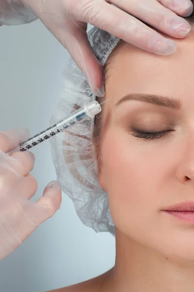 La donna viene iniettata sopra il sopracciglio. Trattamento anti-invecchiamento e lifting facciale. Trattamento cosmetico e chirurgia plastica — Foto Stock