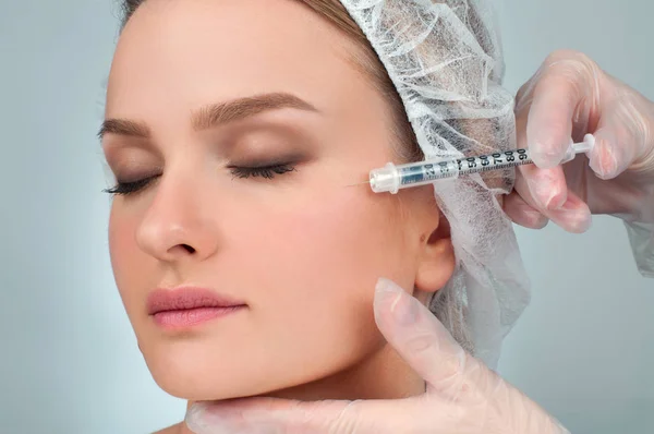 A nő arcán egyre töltőanyag injekciót. Anti-aging kezelés és az arc lift. Kozmetikai kezelés és plasztikai sebészet — Stock Fotó