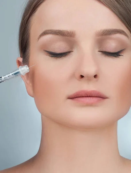 La mujer recibe una inyección de relleno en las mejillas. Tratamiento antienvejecimiento y lifting facial. Tratamiento cosmético y cirugía plástica — Foto de Stock