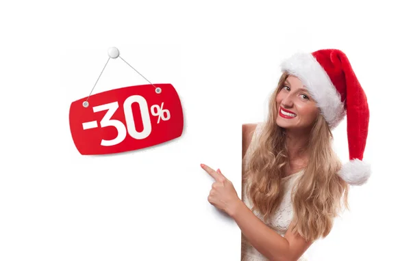 Kerstmis verkoop. Mooie vrouw in KERSTMUTS wijzend op verkoop — Stockfoto