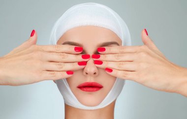 Güzellik, moda ve estetik ameliyat kavramı. Gözleri bandajlı kafa ile kapsayan kadın