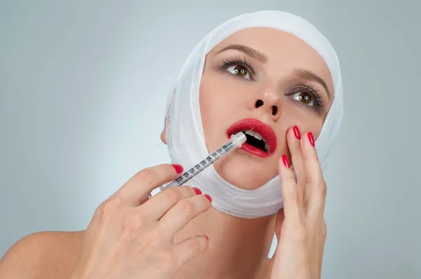 Vacker kvinna få injektion i läppar med bandagerade ansikte. Skönhet, mode och plastikkirurgi konceptet — Stockfoto